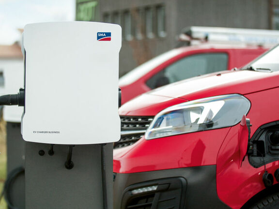 SMA EV Charger Business vor einer Reihe roter Autos auf einem Parkplatz