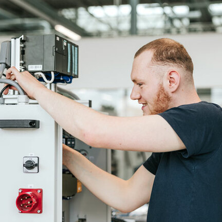 Ein Auszubildender, der an einem Schaltschrank arbeitet. 