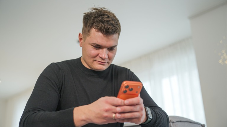 Marcel nutzt sein Smartphone, um seinen dynamischen Stromtarif zu steuern