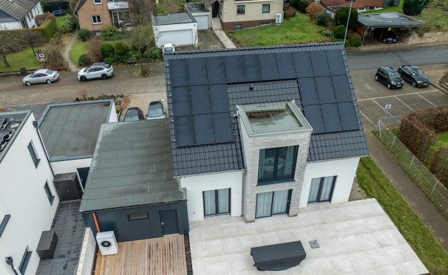 Einfamilienhaus mit großflächiger Photovoltaikanlage auf dem Satteldach, moderner Fassade und großer Terrasse